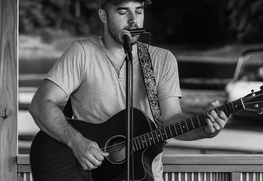 Jacob Cutler performing live with acoustic guitar
                and harmonica