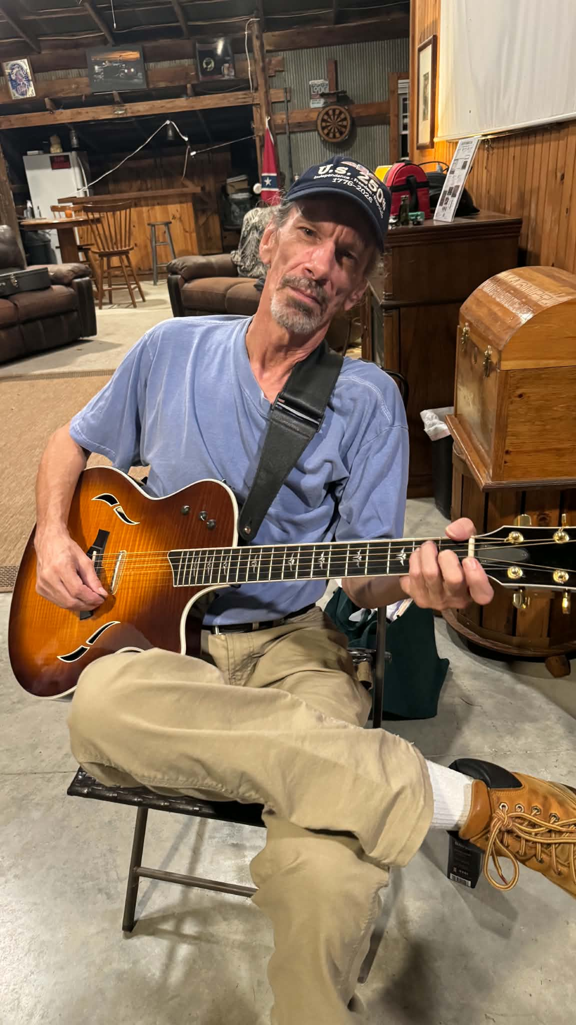 Roy Earl Robison seated with his guitar